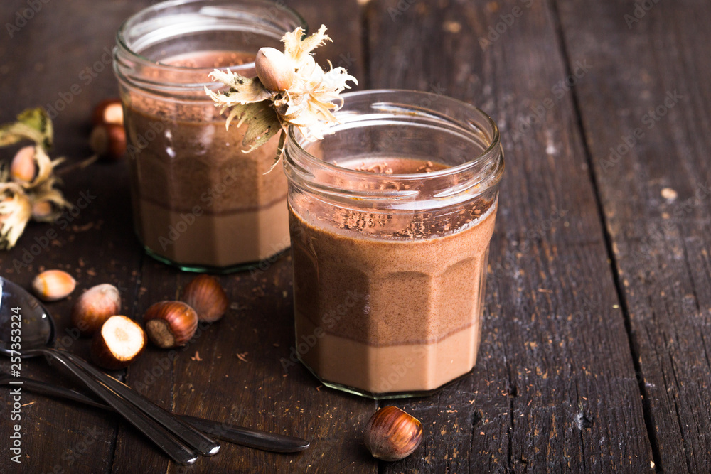 Chocolate pannacotta with nuts on black background. Chocolate pannacotta with nuts on black background.