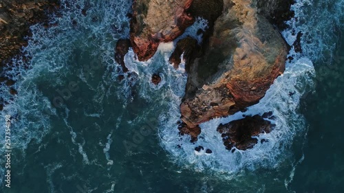 Aerial top view on Atlantic coast with rock cliffs and waves at sunset in Portugal, 4k photo