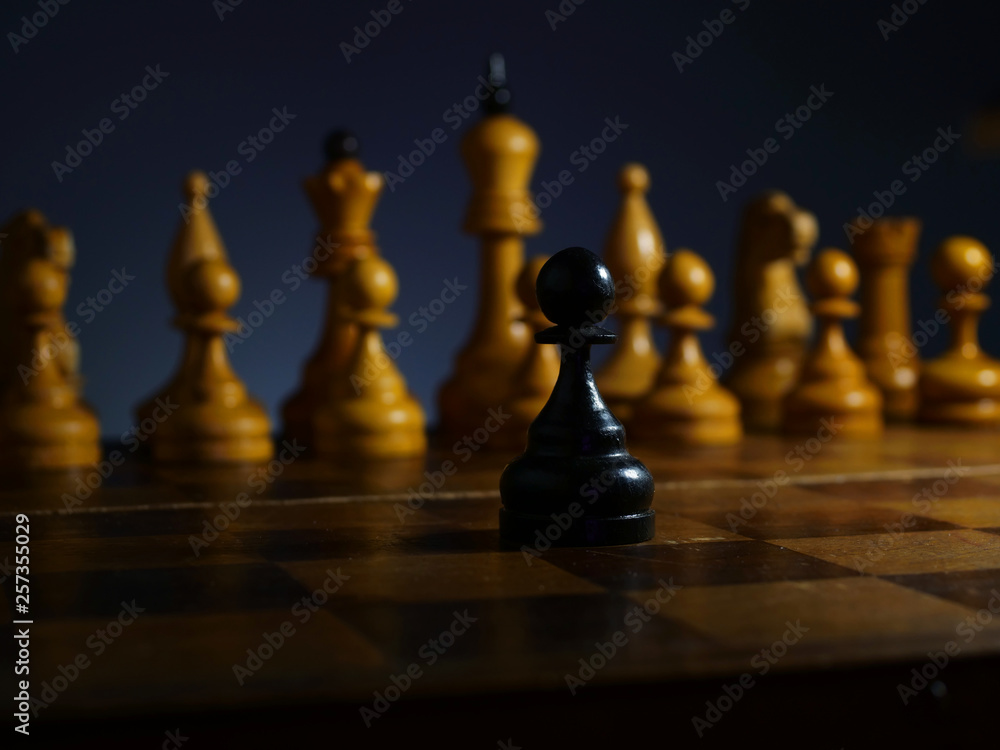 Brave ambitious businessman and challenge. Black wooden pawn and white chess. Brave ambitious businessman and challenge. Black wooden pawn and white chess.