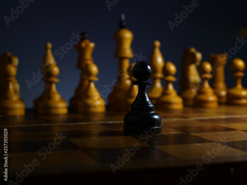 Brave ambitious businessman and challenge. Black wooden pawn and white chess.