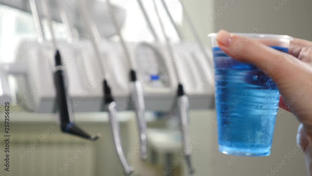 Modern dental clinic. Medical equipment in disfocus with plastic cup with blue aseptic liquid in front. 4k Modern dental clinic. Medical equipment in disfocus with plastic cup with blue aseptic liquid in front. 4k