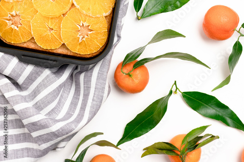 Fototapeta Naklejka Na Ścianę i Meble -  Orange-mandarin pie in baking dish on a striped linen towel