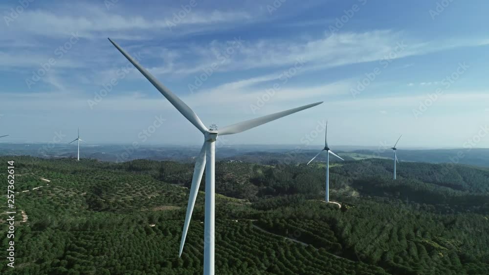 Aerial view of windmills or wind turbine on wind farm in rotation to generate electricity energy, 4k