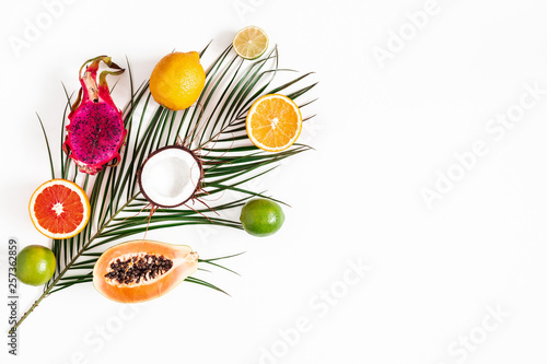 Fruits and palm leaves on white background. Tropical fruits. Summer concept. Flat lay, top view, copy space