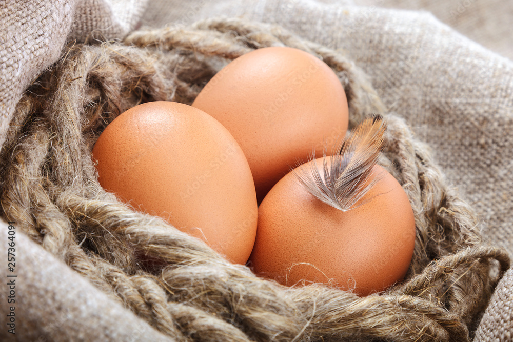 Chicken eggs in a wicker basket on canvas Chicken eggs in a wicker basket on canvas