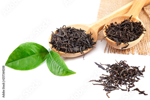 Black tea in a wooden spoon isolated on white background