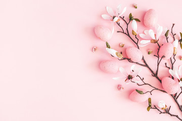 Easter composition. Easter eggs, pink flowers on pastel pink background. Flat lay, top view, copy space
