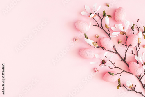 Easter composition. Easter eggs, pink flowers on pastel pink background. Flat lay, top view, copy space