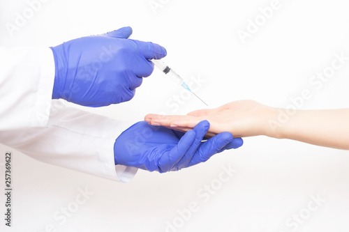 The doctor makes a shot of botulinum toxin in the hand of the girl's palm against excessive sweating, treatment of hyperhidrosis, medical, close-up, discomfort