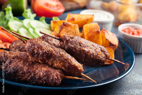 Grilled shish kebab served with fried potatoes