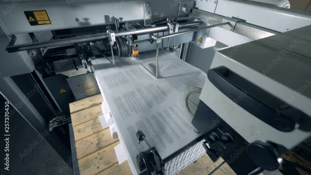 Printed pieces of paper are entering a conveyor machine Printed pieces of paper are entering a conveyor machine