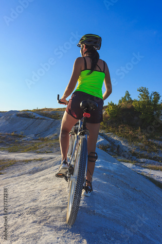 Fototapeta Naklejka Na Ścianę i Meble -  Young sporty woman with a bike, soft focus background