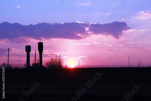 Fototapeta Naklejka Na Ścianę i Meble -  two water towers and beautiful sunset