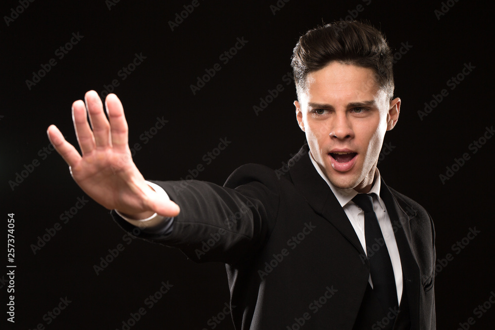 Professional bodyguaard in a black suit screaming gesturing with his palm to stom aggressive protection guarding professionalism job safety saving gesture brutal emotions protective masculine Professional bodyguaard in a black suit screaming gesturing with his palm to stom aggressive protection guarding professionalism job safety saving gesture brutal emotions protective masculine