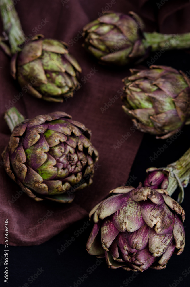 Fototapeta premium fresh purple artichokes on black background