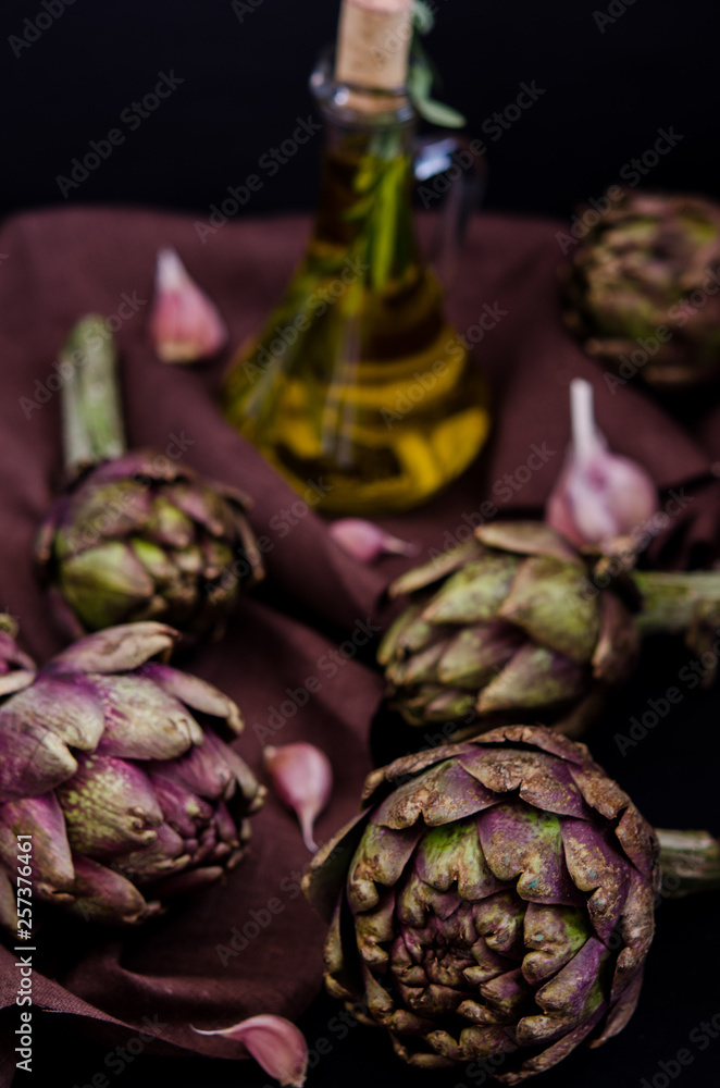 Obraz premium fresh purple artichokes on black background