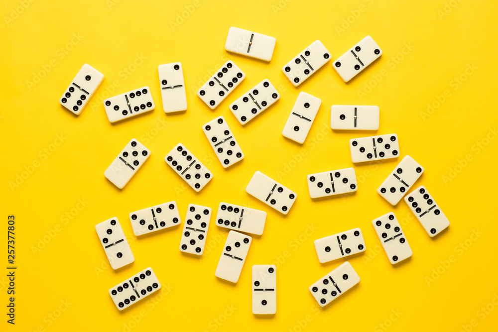 Domino pieces over bright yellow background, top view. Flat lay background. Domino pieces over bright yellow background, top view. Flat lay background.
