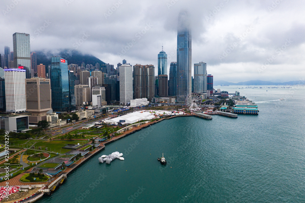 Hong Kong, China - March, 24, 2019: KAWS:holiday Following the trips in Seoul and Taipei, I came to Hong Kong this time.I am now lying on the surface of the Victoria Harbour, basking  in the sunshine.