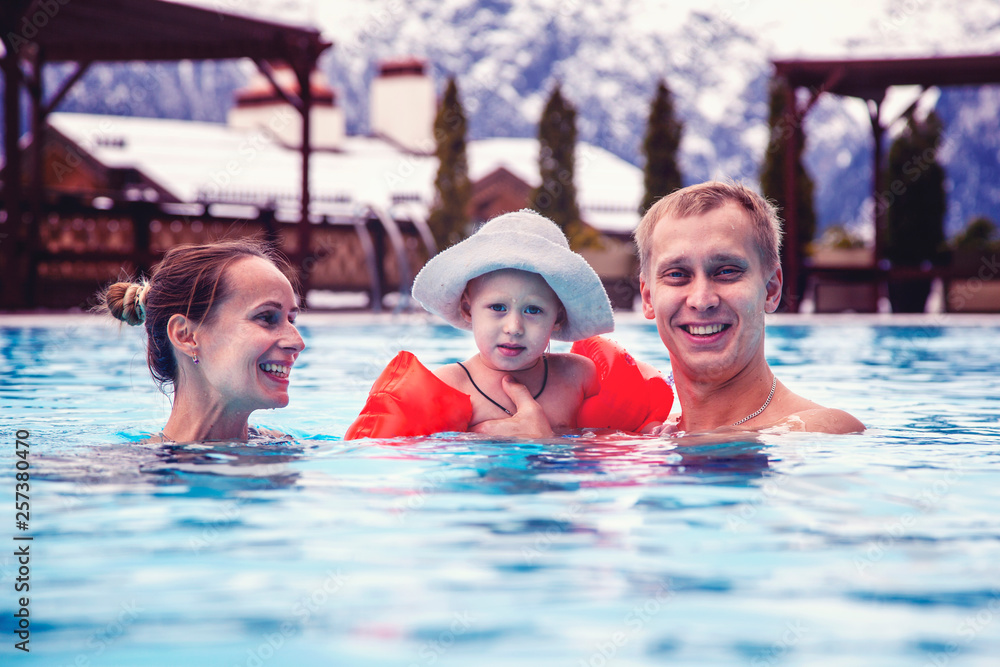 Obraz premium happy family relaxing in the spa center with a child swims in the pool