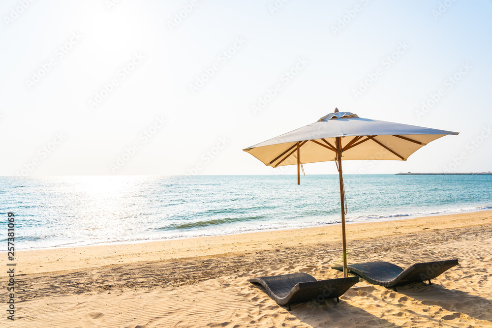 Obraz premium Chair umbrella and lounge on the beautiful beach sea ocean on sky