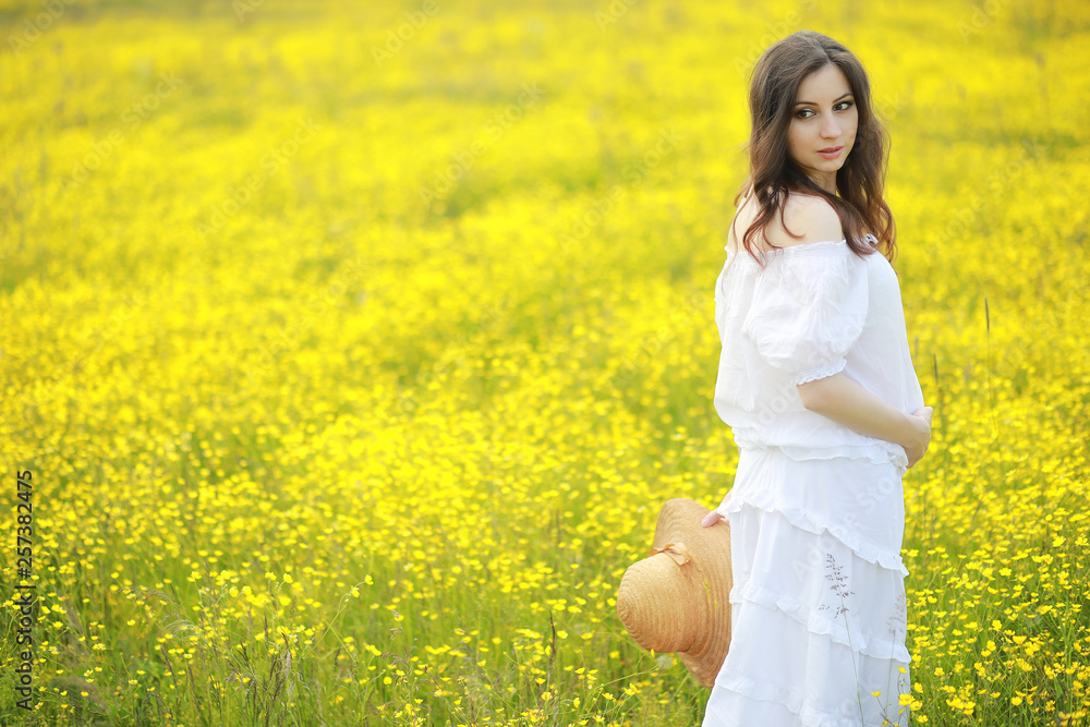Pregnant woman in a dress in a field of flowers Pregnant woman in a dress in a field of flowers