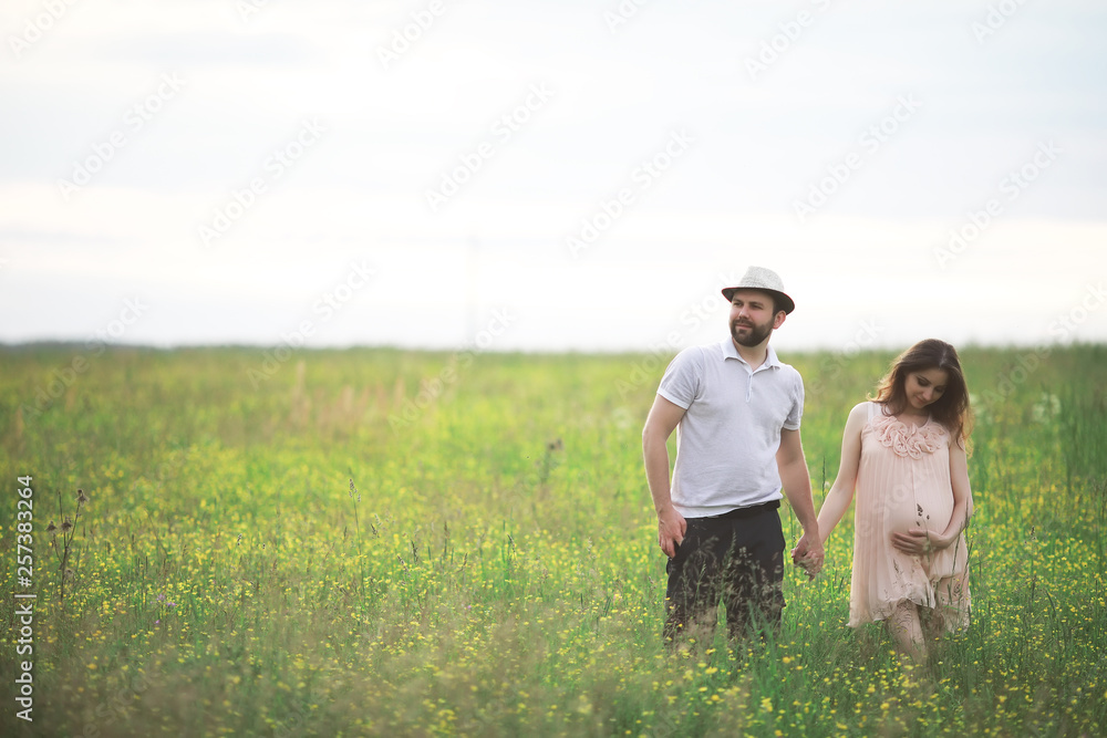 Couple man and pregnant girl in the field