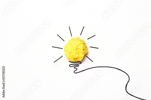  creative concept "idea", a new idea. Painted light bulb with a crumpled paper yellow ball.