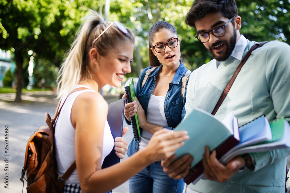 Obraz premium Happy university friends studying together in college