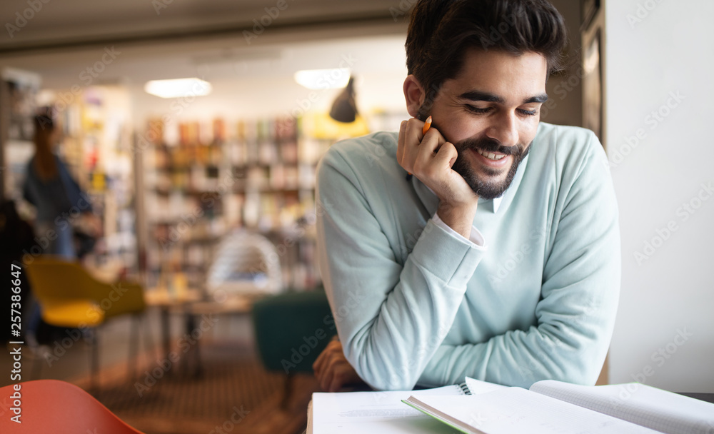 Happy student preparing exam and learning lessons in college library Happy student preparing exam and learning lessons in college library