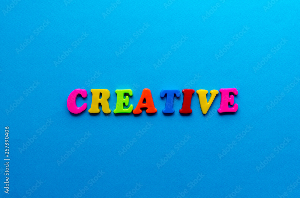 text creative from plastic colored letters on blue paper background text creative from plastic colored letters on blue paper background
