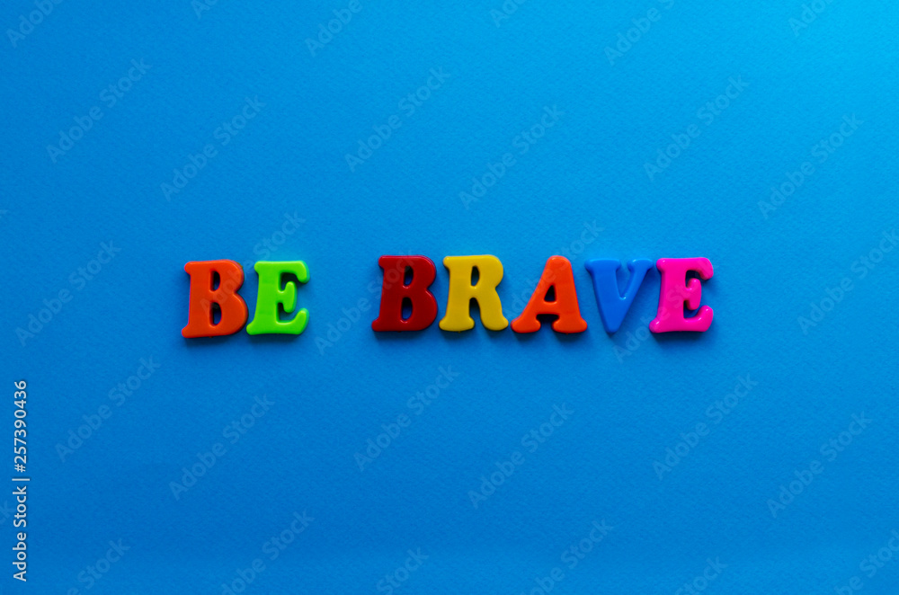 text be brave from plastic colored letters on blue paper background text be brave from plastic colored letters on blue paper background