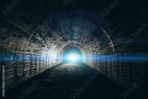 Light in end of tunnel. Long underground concrete corridor in abandoned bunker or nuclear shelter