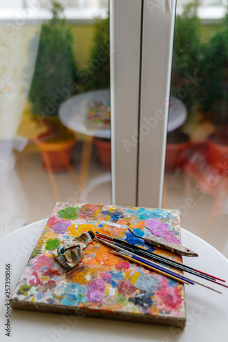 Artistic paint brushes and palette in the studio 