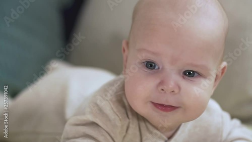 Close up of baby luying on bed. Childhood, babyhood and people concept. photo