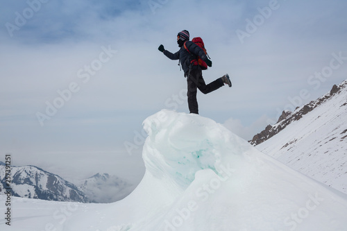 Extreme winter sports: climber reaches the top of a snowy peak in the Alps. Concepts: determination, success, strength.