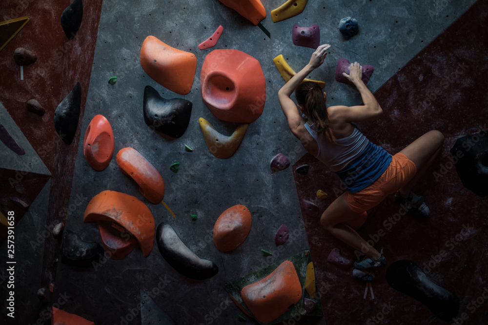 Athletic woman practicing in a bouldering gym