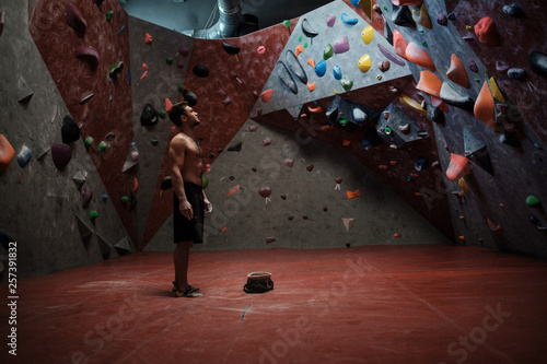 Athletic man practicing in a bouldering gym photo