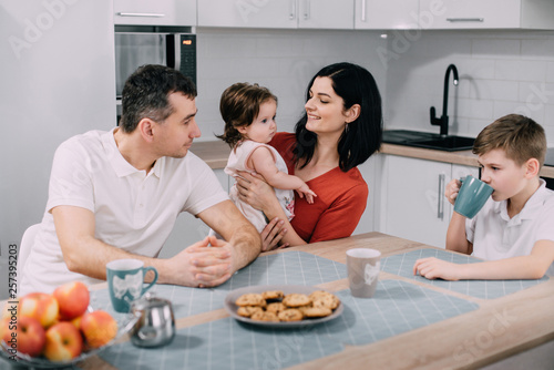 Happy family eating cookies in kitchen