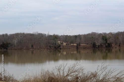 A view of the lake in the park on a cloudy overcast day.