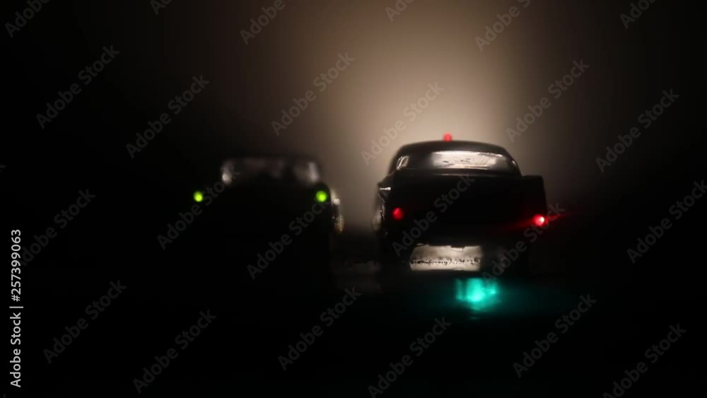 Police car chasing a car at night with fog background. 911 Emergency response police car speeding to scene of crime. Selective focus Police car chasing a car at night with fog background. 911 Emergency response police car speeding to scene of crime. Selective focus