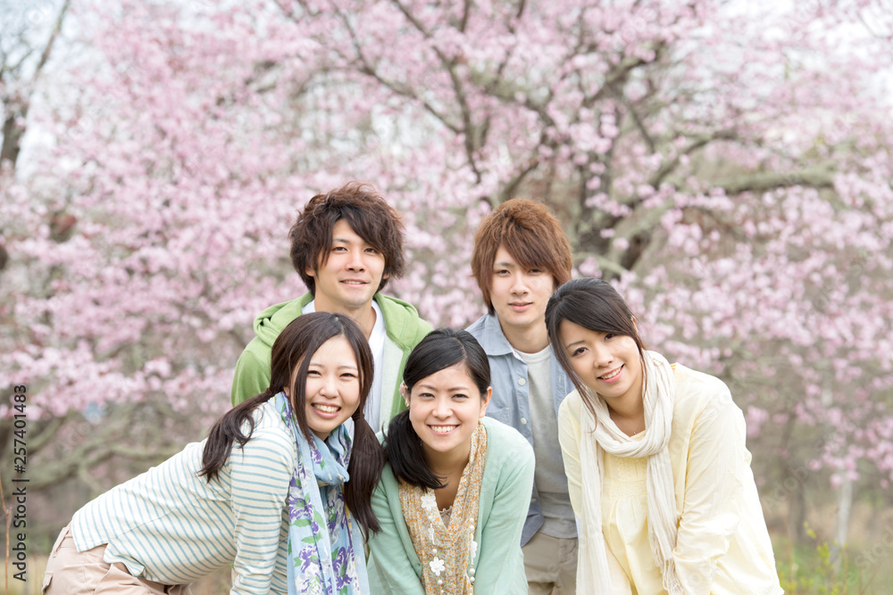 桜の前で微笑む若者たち