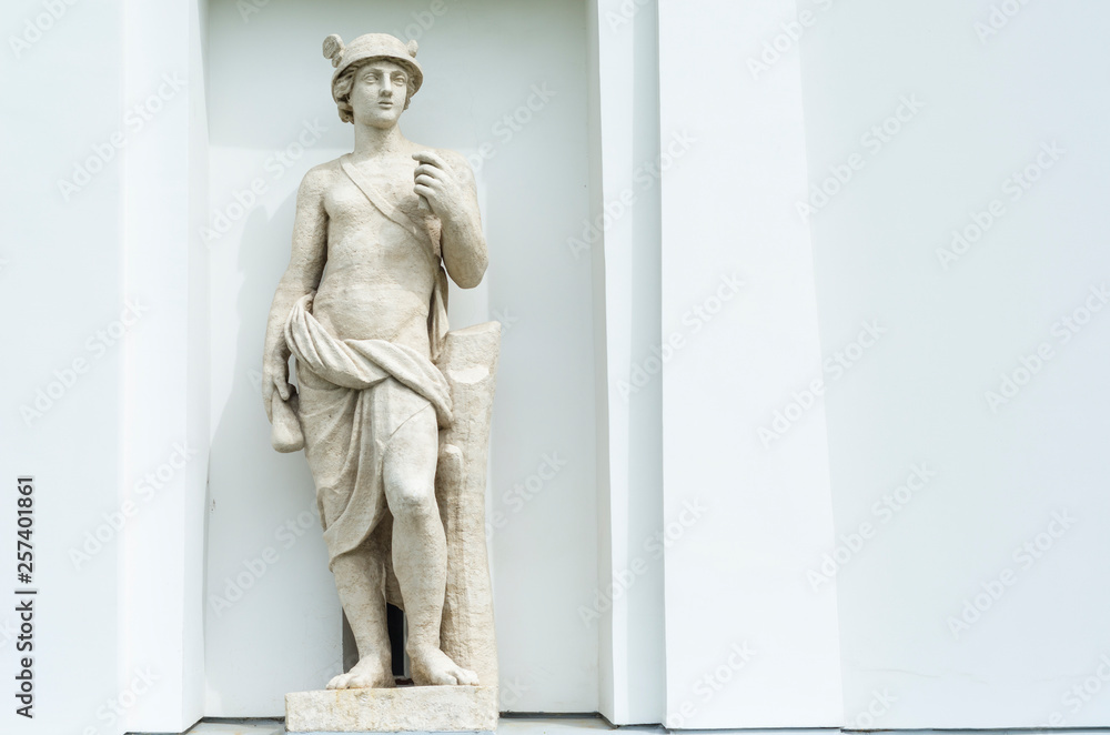 statue in the portico of a building on a neutral light background