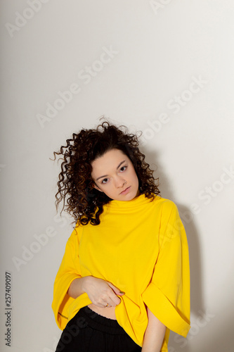 People, youth, leisure and lifestyle concept. Fashionable Caucasian young female student wearing stylish clothing laughing happily, having fun in photo studio. Copy Space © Максим Галінский