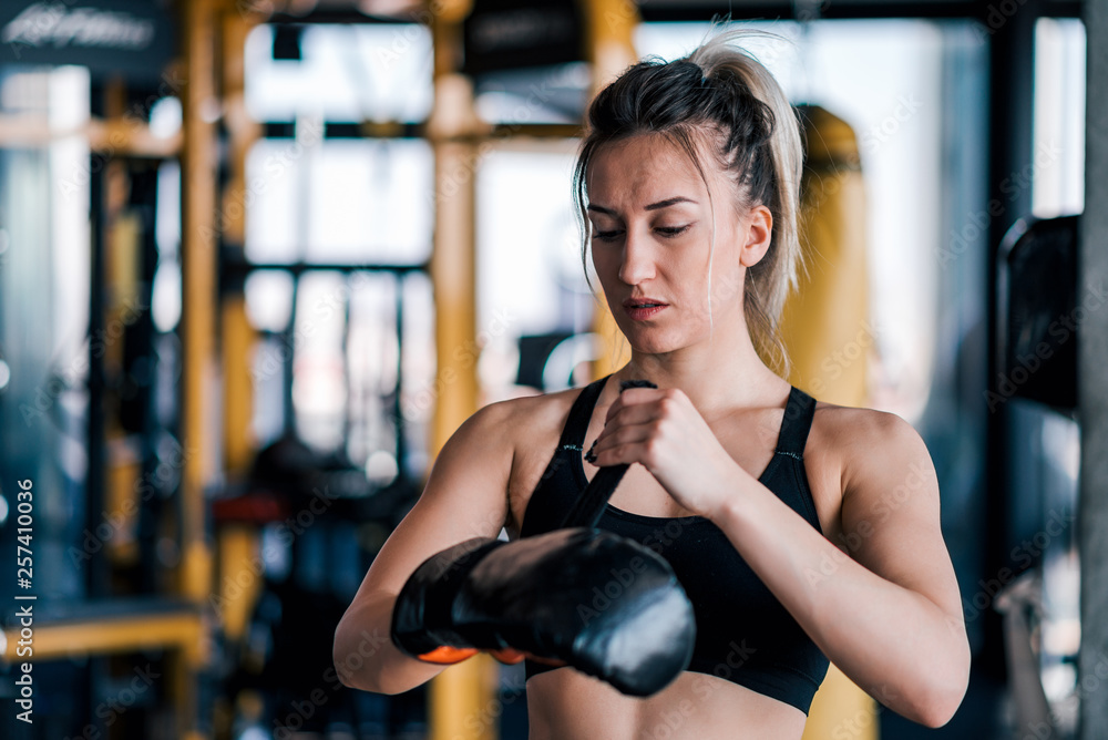 Fit female fighter preparing for workout. Fit female fighter preparing for workout.