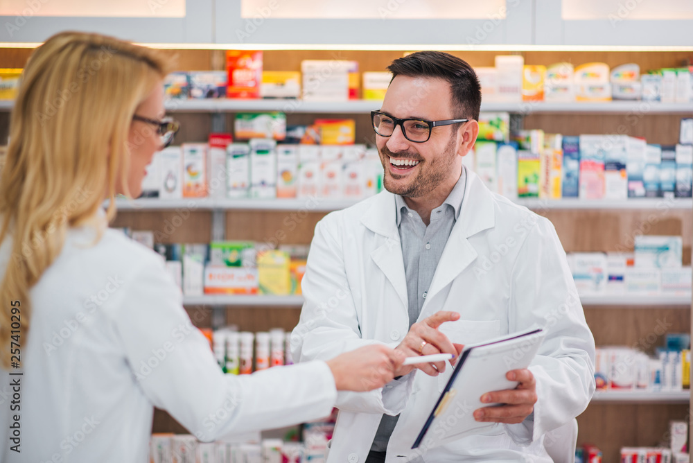 Two cheerful pharmacists working together. Two cheerful pharmacists working together.
