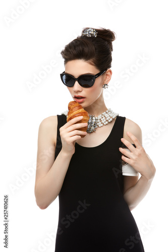 beautiful young woman in retro style with croissant