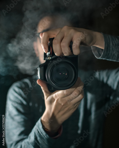 Professional photographer with a camera. Black background.
