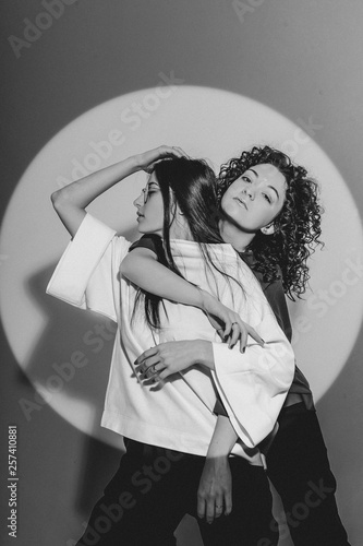 Fashionable Caucasian young female women wearing stylish clothing laughing happily, having fun in photo studio. People, youth, leisure and lifestyle concept. Copy Space