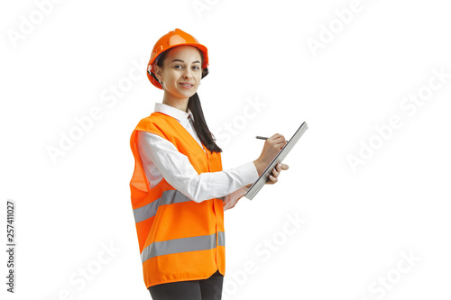 Destroying gender stereotypes. Female builder in orange helmet standing on white studio background. Safety specialist, engineer, occupation, businesswoman, job concept. Woman in the male profession