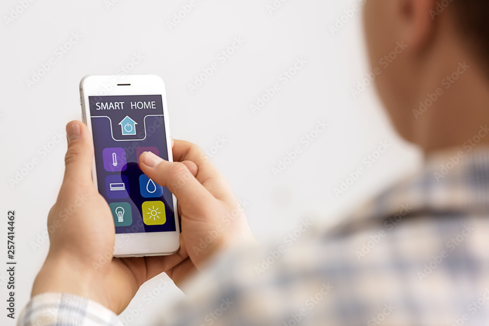 Teenage boy using application of smart home automation Teenage boy using application of smart home automation